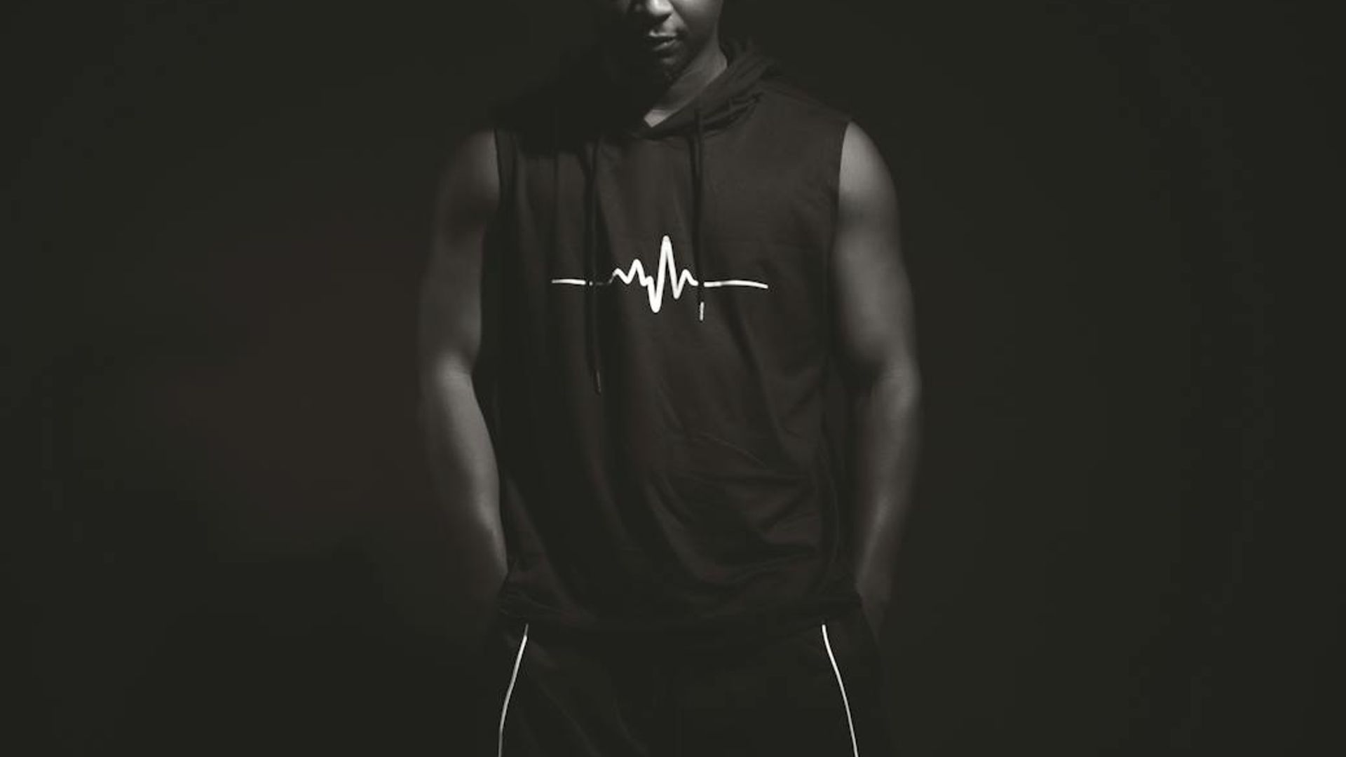 Man performing a controlled strength exercise in a minimalist dark gym.